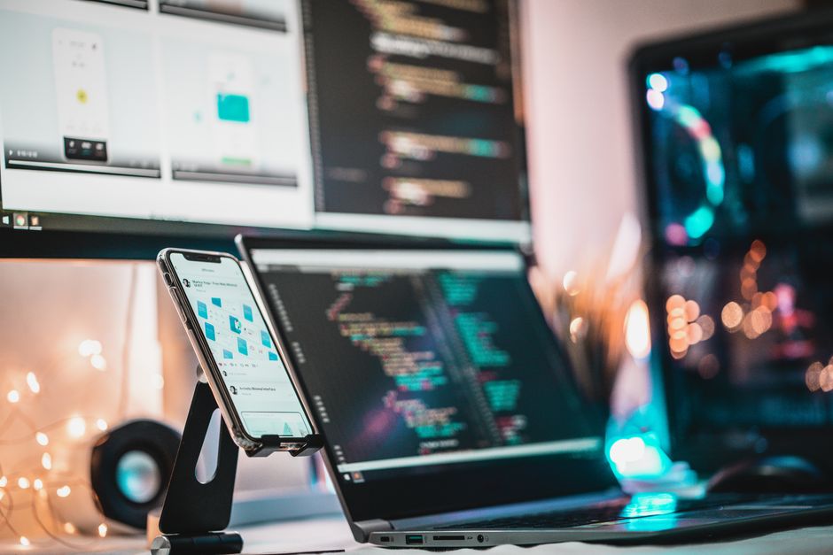 Close-up tech setup with gadgets and coding screen