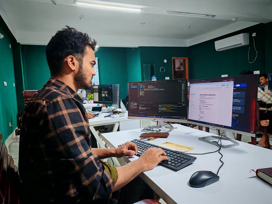 Software developer working on code at dual monitor setup